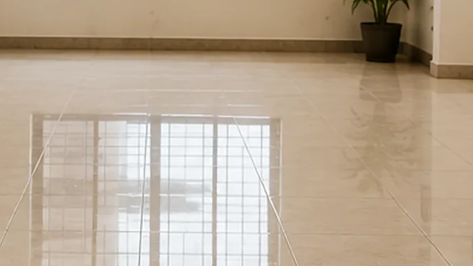 Illustrative image: a glossy tiled floor with even grout lines, reflecting the light from a window.